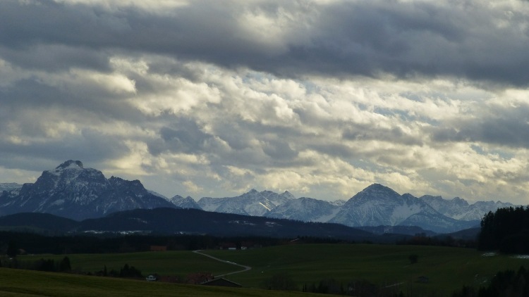 Eine Landschaft im Allgäu. Wolkenüberhangene Berggipfel.